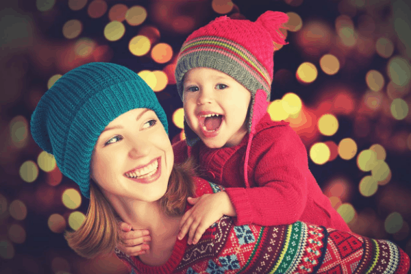 Solar Christmas lights sparkle and shine behind a mom and her little girl